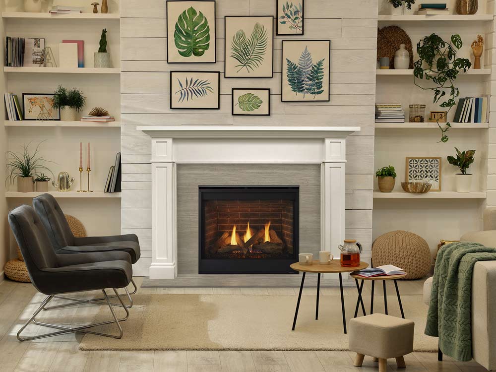 Majestic Quartz gas fireplace with brick interior and black edge surrounded by gray tile and white mantel with botanical prints above flanked by shelves in sitting room