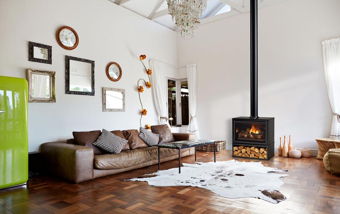 Majestic Trilliant freestanding gas fireplace in cabinet in front of brick wall in slate gray industrial loft