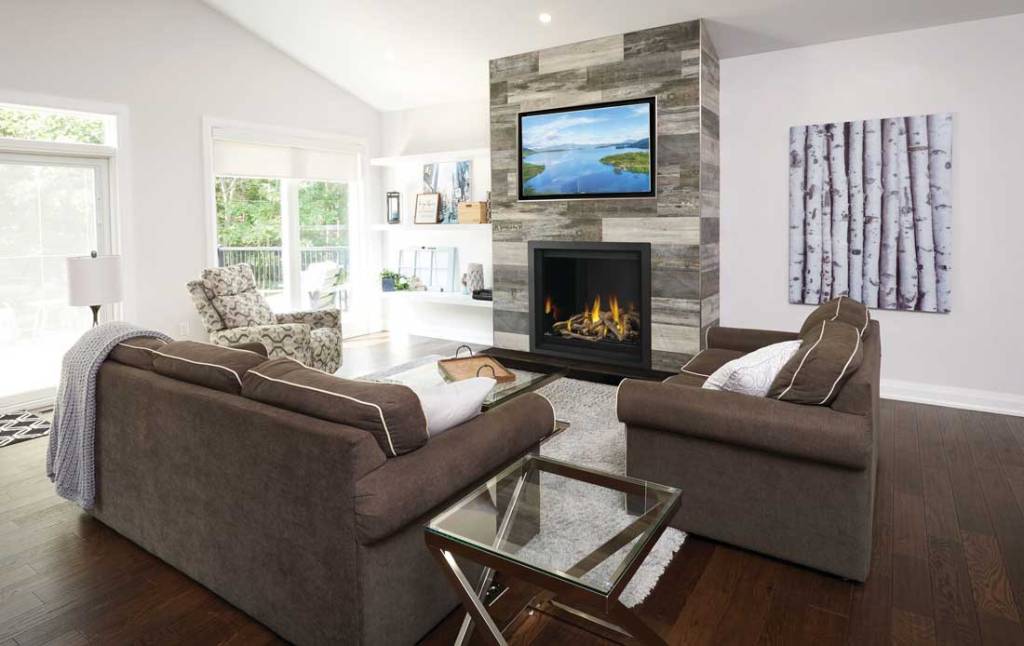 Napoleon Altitude X gas fireplace with gray tile surround in living space with brown sofas and chair