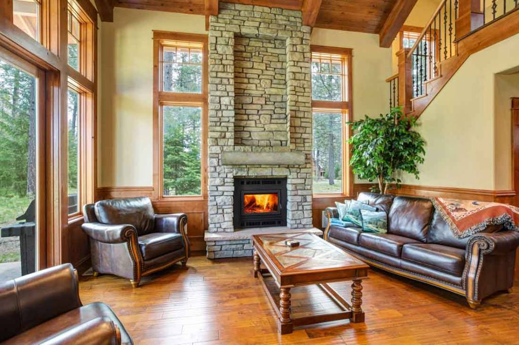 Majestic Pioneer III wood burning fireplace installed in living room with stone facing and concrete mantel