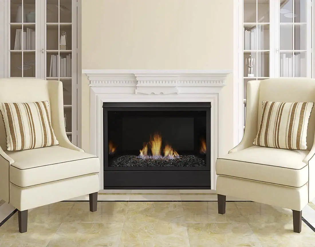 Monessen Aria vent free gas fireplace with white mantel flanked by white enclosed book cases and cream side chairs with striped pillows.